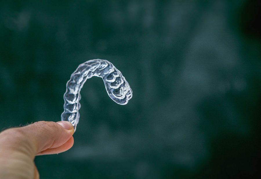 A clear removable aligner in its case.